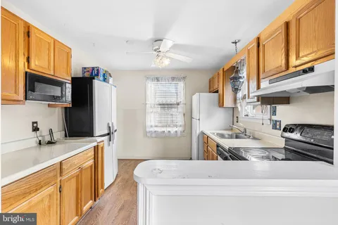a kitchen with stainless steel appliances granite countertop a sink stove refrigerator granite counter tops wooden cabinets and a refrigerator