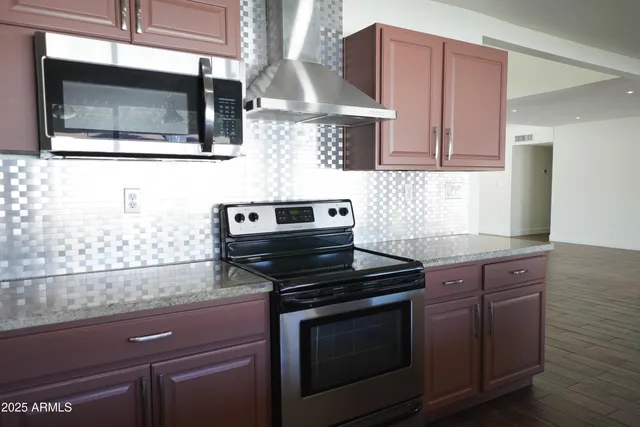 a kitchen with stainless steel appliances wooden cabinets stove and microwave