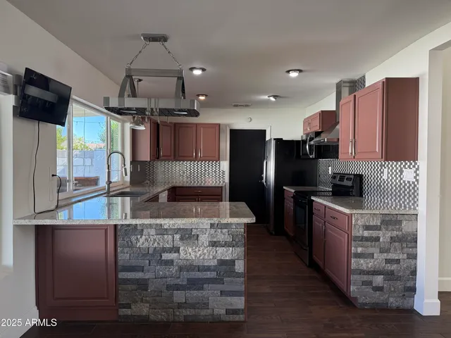 a kitchen with kitchen island granite countertop a large counter top stainless steel appliances and cabinets
