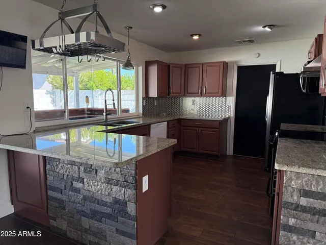 a kitchen with stainless steel appliances granite countertop a stove and a refrigerator