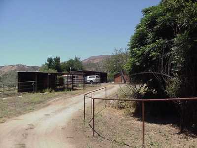 12533 Sisar Road Ojai, CA 93023 - Photo 1 of 1 dirt road in and horse cover. house is to the right of white car.