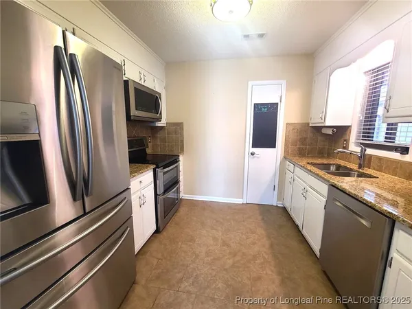 a large kitchen with a refrigerator and a sink