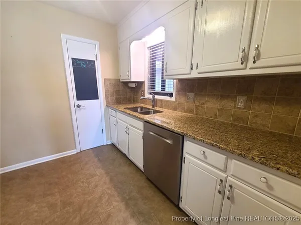 a kitchen with granite countertop cabinets stainless steel appliances a sink and a window