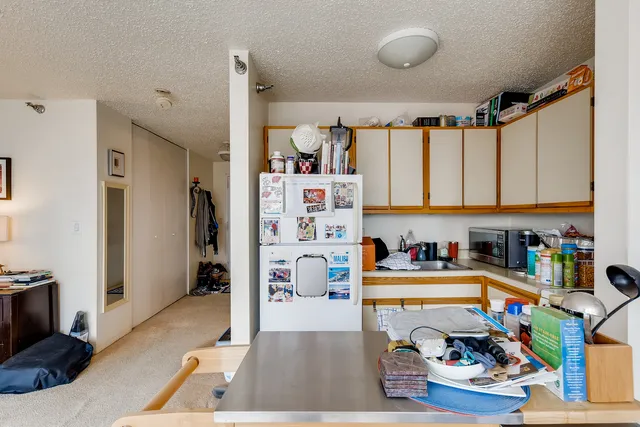 a kitchen with lots of clutter and stainless steel appliances