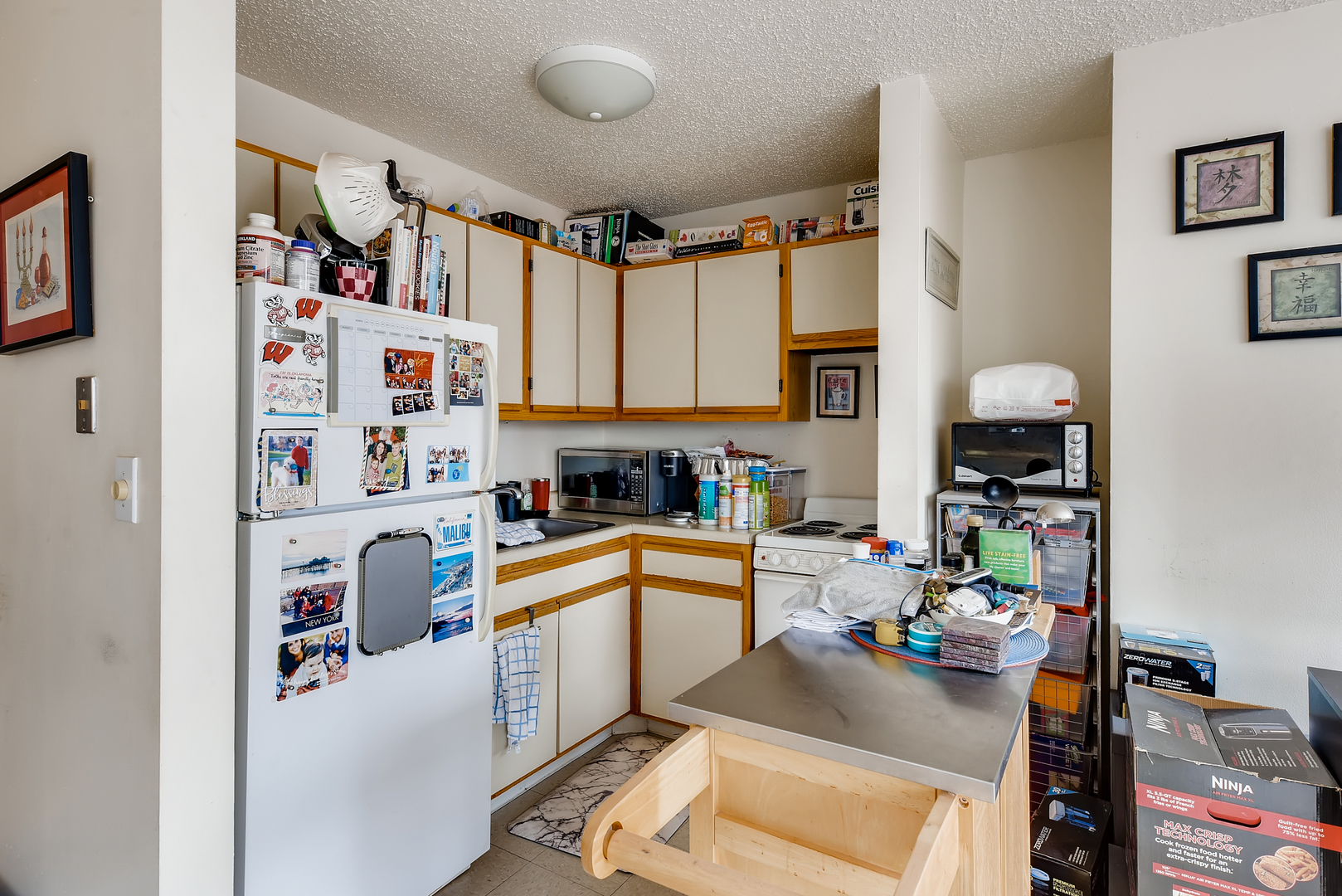 1122 North Clark Street, Unit 2207 Chicago, IL 60610 - Photo 9 of 14 a kitchen with a refrigerator a sink a stove and wooden floor