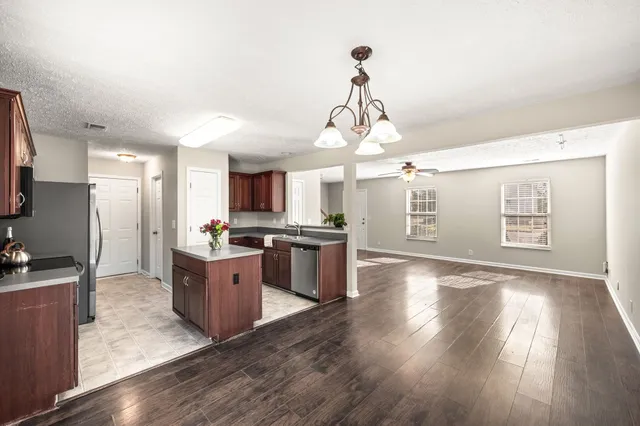 a open kitchen with stainless steel appliances granite countertop a stove and wooden floor