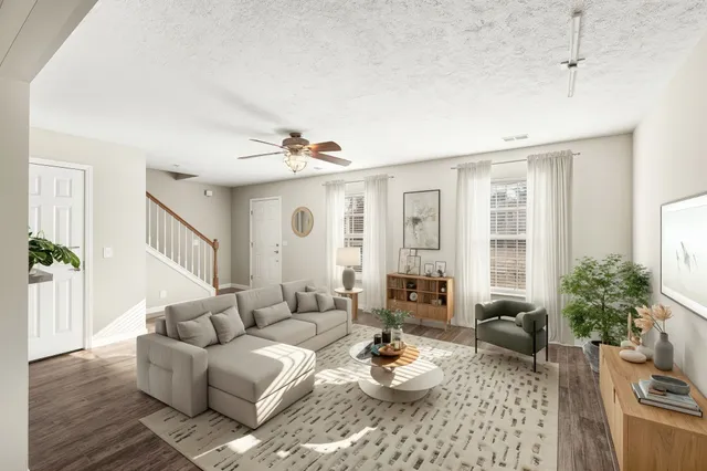 a living room with furniture and wooden floor