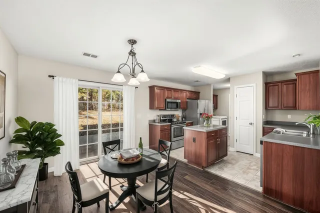 a view of a dining room with furniture and a kitchen