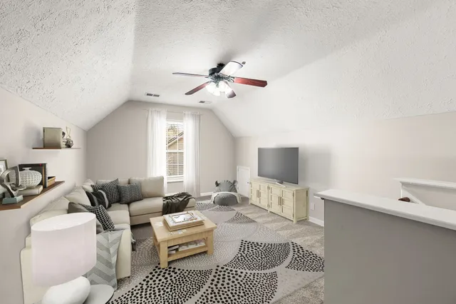 a living room with furniture a ceiling fan and a rug