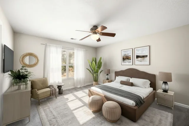 a bedroom with a bed couches chandelier and a window