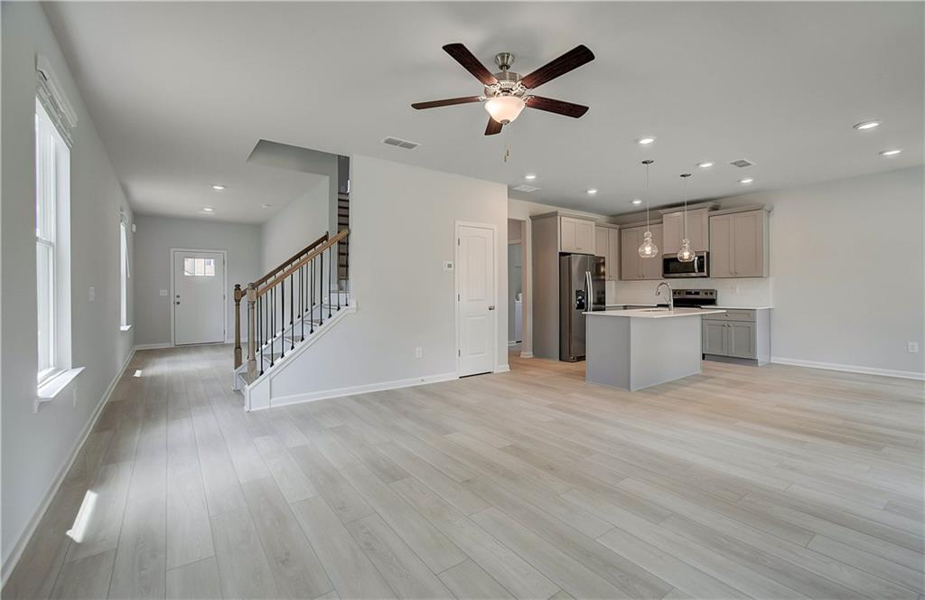 117 Alpine Road Fairburn, GA 30213 - Photo 7 of 29 a view of a kitchen with a sink stainless steel appliances wooden floor and a window