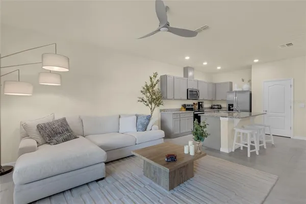 a living room with furniture white walls and kitchen view