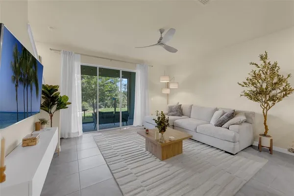 a living room with furniture a flat screen tv and a large window