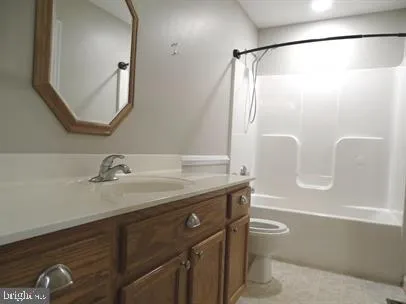 a bathroom with a granite countertop sink a toilet a mirror and shower