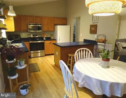 a kitchen with stainless steel appliances granite countertop a stove a sink a microwave and dining table