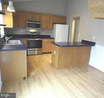 a kitchen with stainless steel appliances a stove a sink and a microwave