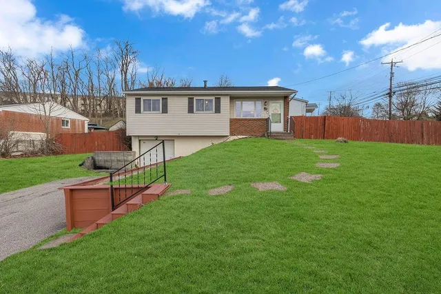 a view of a house with a yard and sitting area