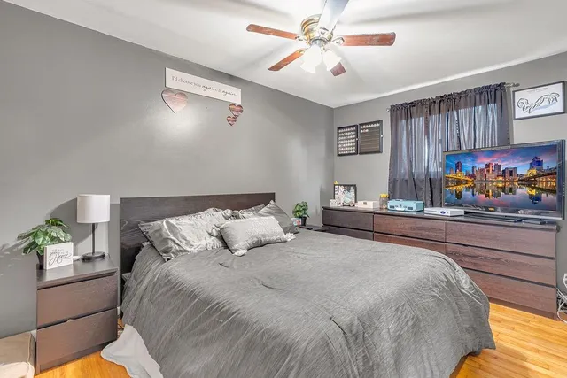 a bedroom with bed and ceiling fan