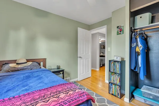 a bedroom with a bed and a lamp on dresser