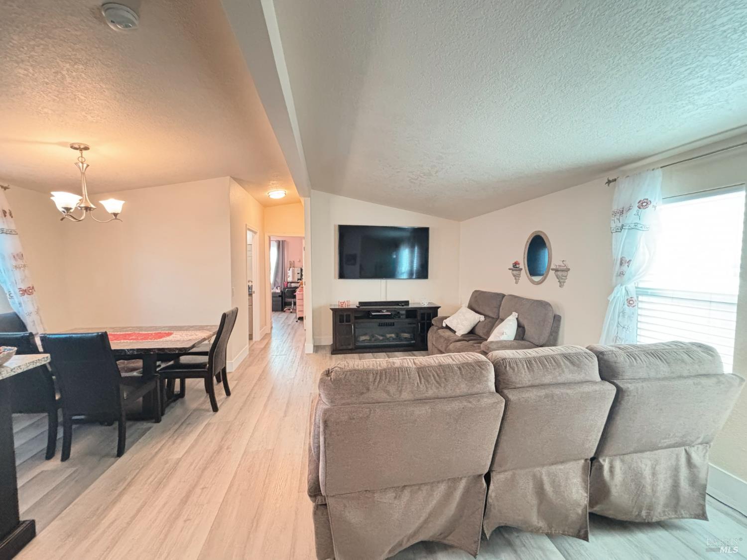 3309 South Santa Rosa Avenue South, Unit 16 Santa Rosa, CA 95407 - Photo 12 of 16 a living room with furniture a flat screen tv and kitchen view