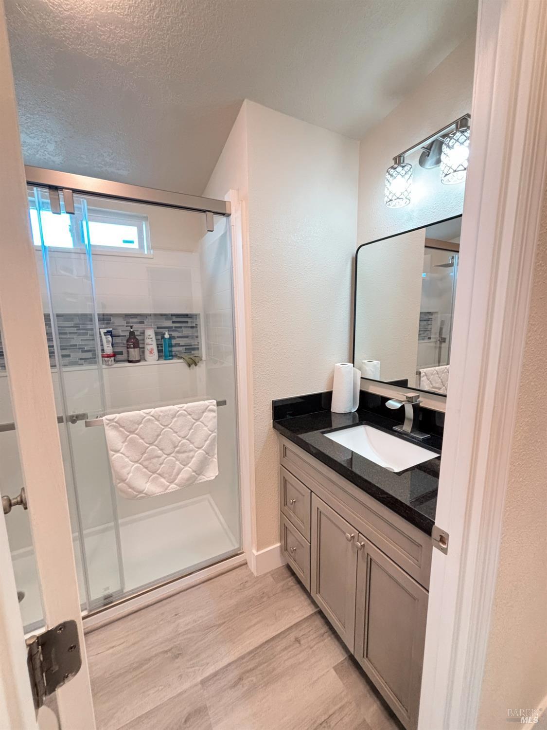 3309 South Santa Rosa Avenue South, Unit 16 Santa Rosa, CA 95407 - Photo 15 of 16 a bathroom with a granite countertop sink and a mirror