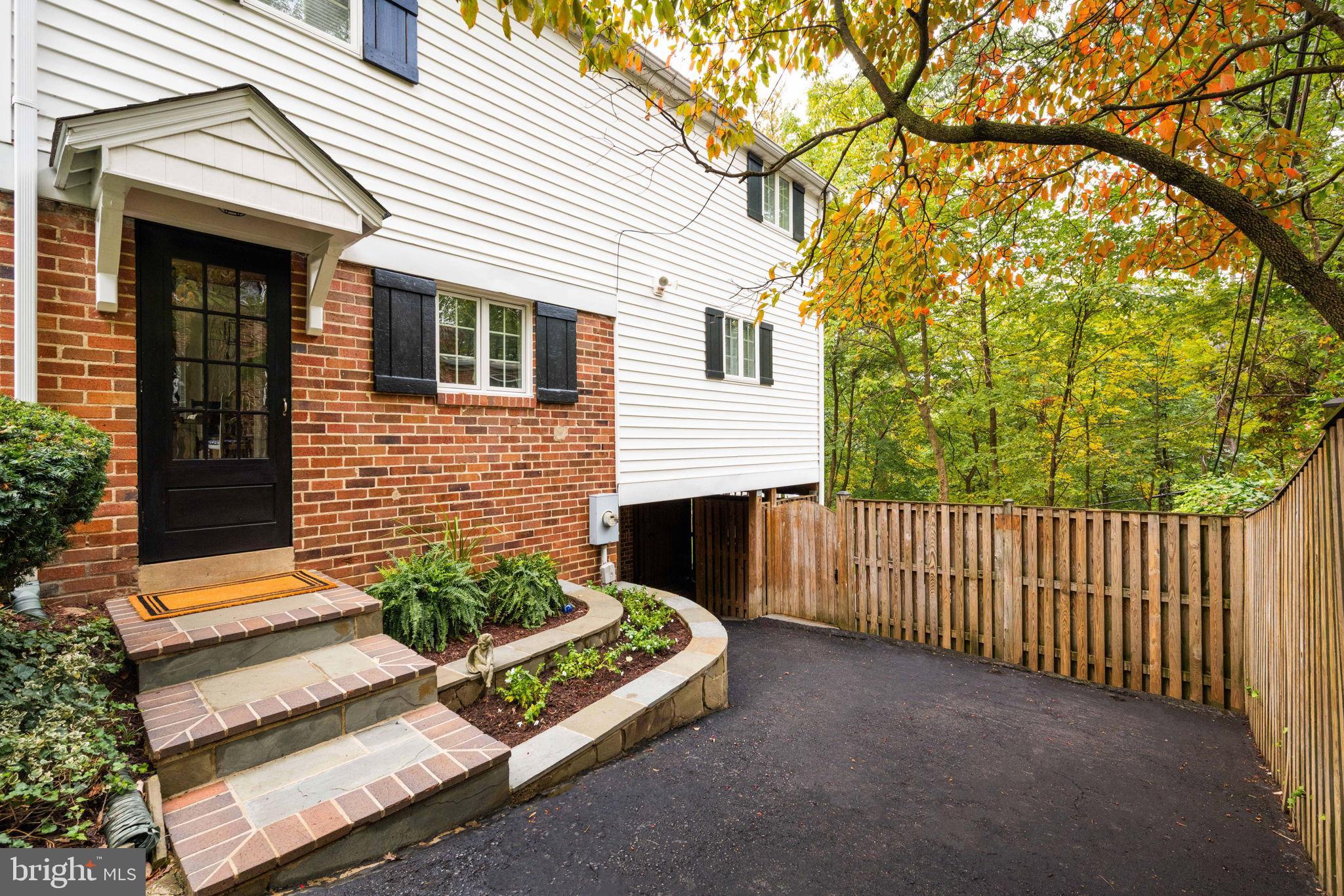 3203 Circle Hill Road Alexandria, VA 22305 - Photo 4 of 48 a view of a house with a small yard and wooden fence and large trees