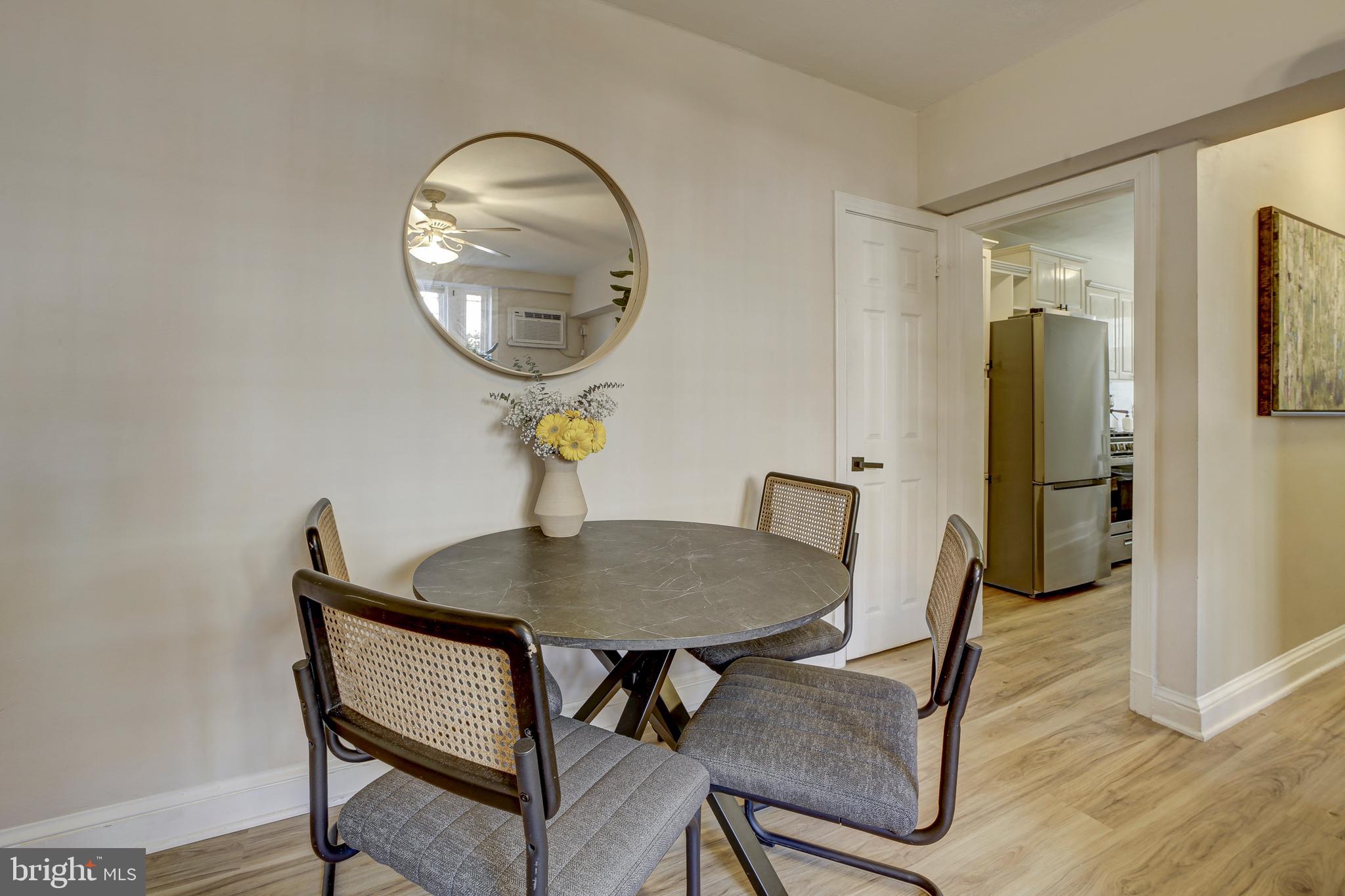 1404 Tuckerman Street Northwest, Unit 1 Washington, DC 20011 - Photo 5 of 18 a dining room with wooden floor a glass table and chairs