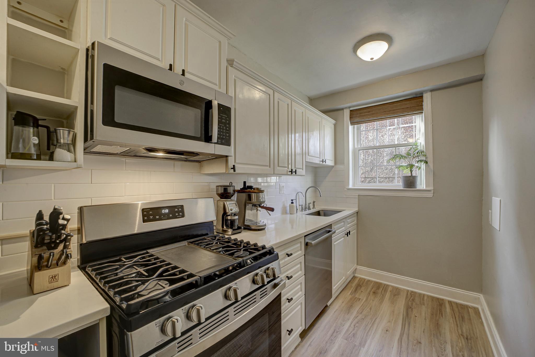 1404 Tuckerman Street Northwest, Unit 1 Washington, DC 20011 - Photo 6 of 18 a kitchen with stainless steel appliances a stove a microwave and cabinets