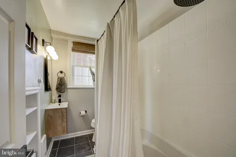 a bathroom with a sink and mirror with bathtub