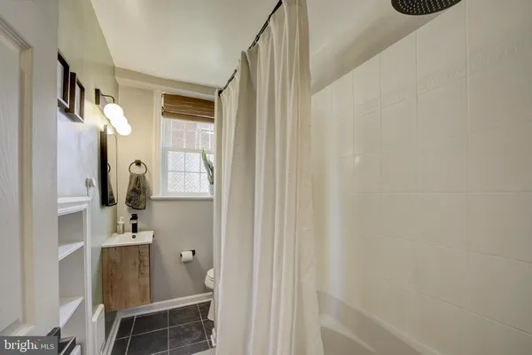 a bathroom with a sink and mirror with bathtub