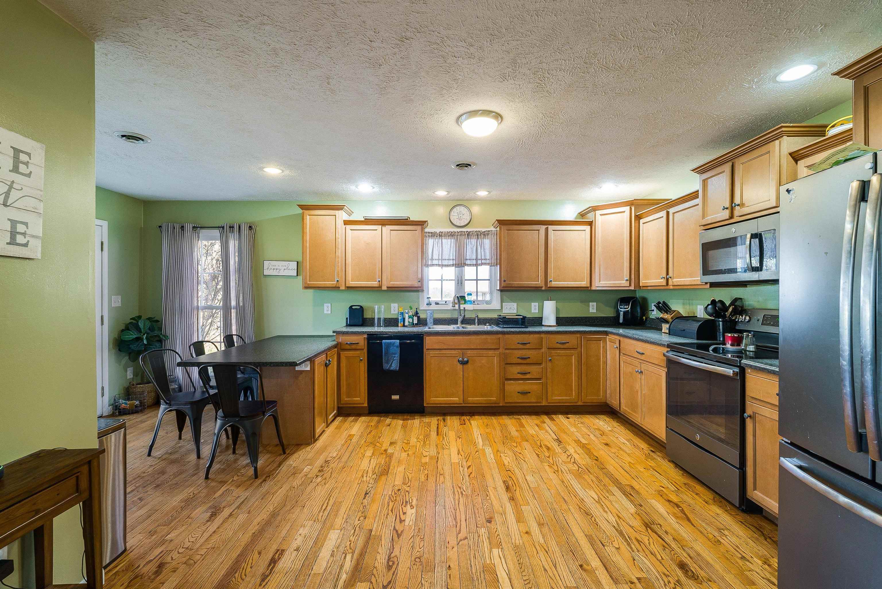 7110 Rocky Bar Road Elkton, VA 22827 - Photo 12 of 52 a kitchen with stainless steel appliances kitchen island granite countertop wooden floors and white cabinets