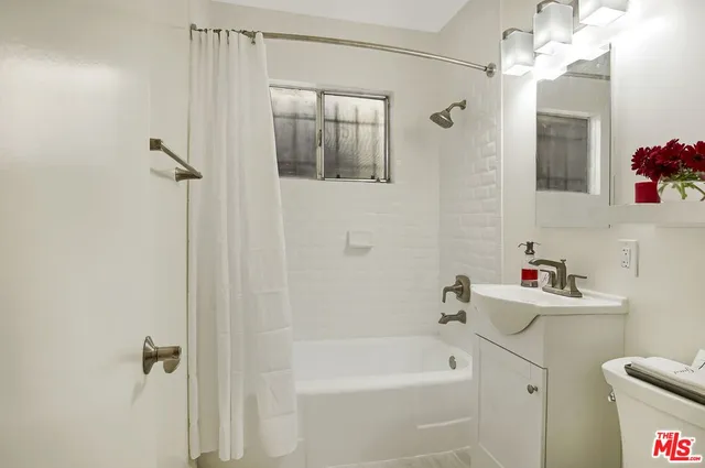 a bathroom with a sink mirror toilet and bathtub