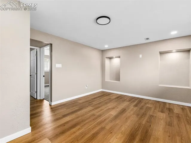 a view of an empty room with wooden floor