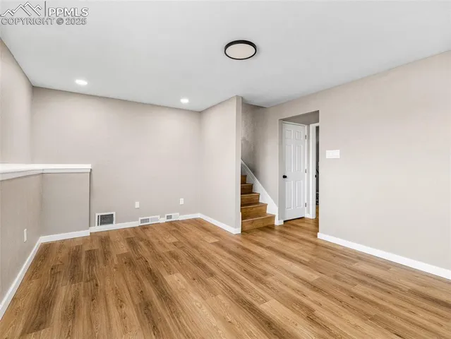 a view of an empty room with wooden floor