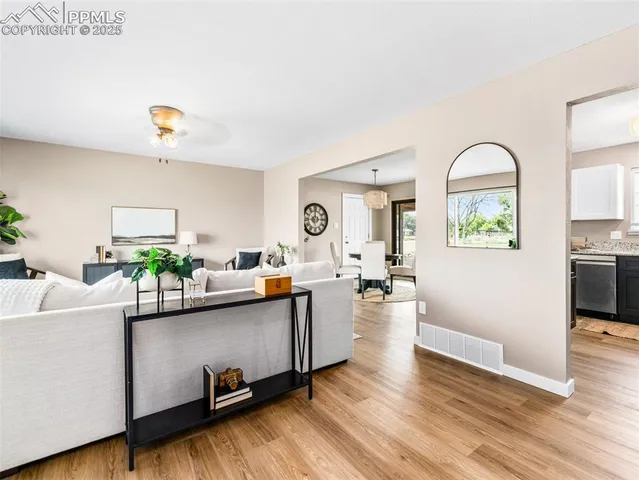 a living room with furniture and a wooden floor