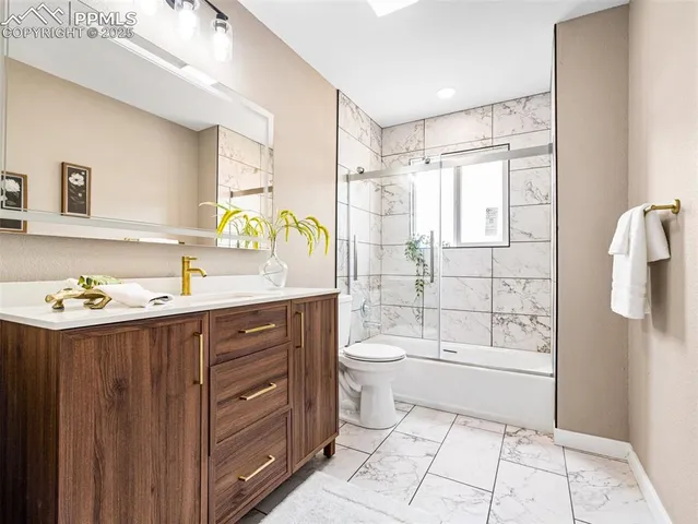 a bathroom with a sink a toilet and shower