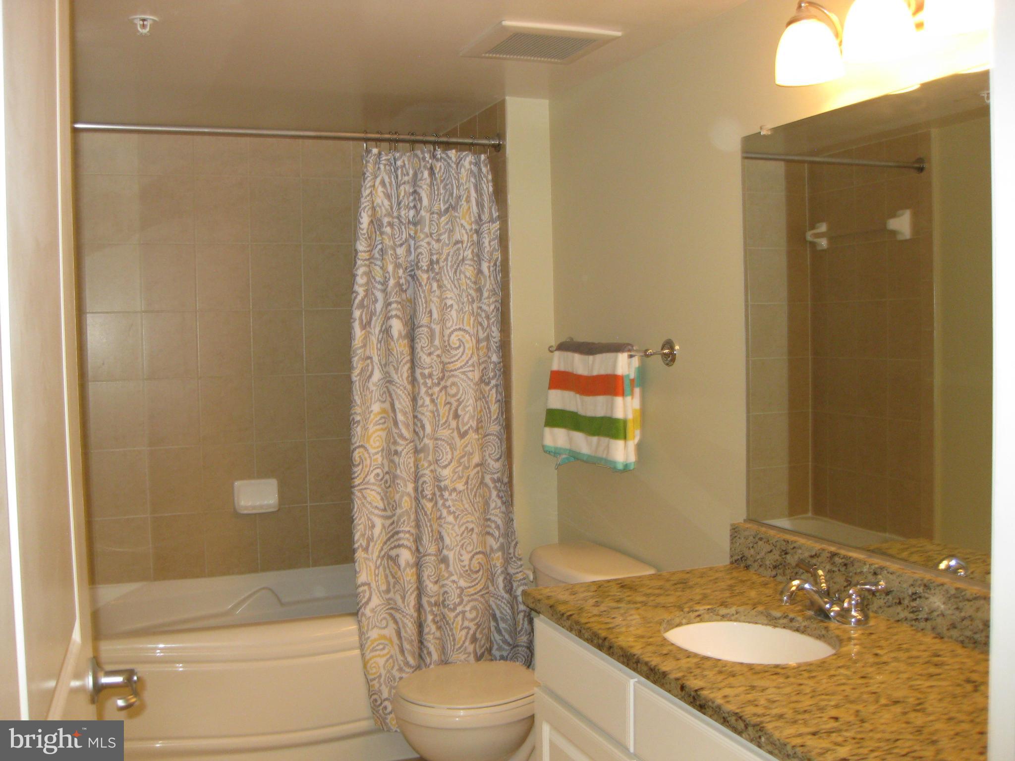 11800 Sunset Hills Road, Unit 925 Reston, VA 20190 - Photo 2 of 29 a bathroom with a granite countertop sink toilet and shower
