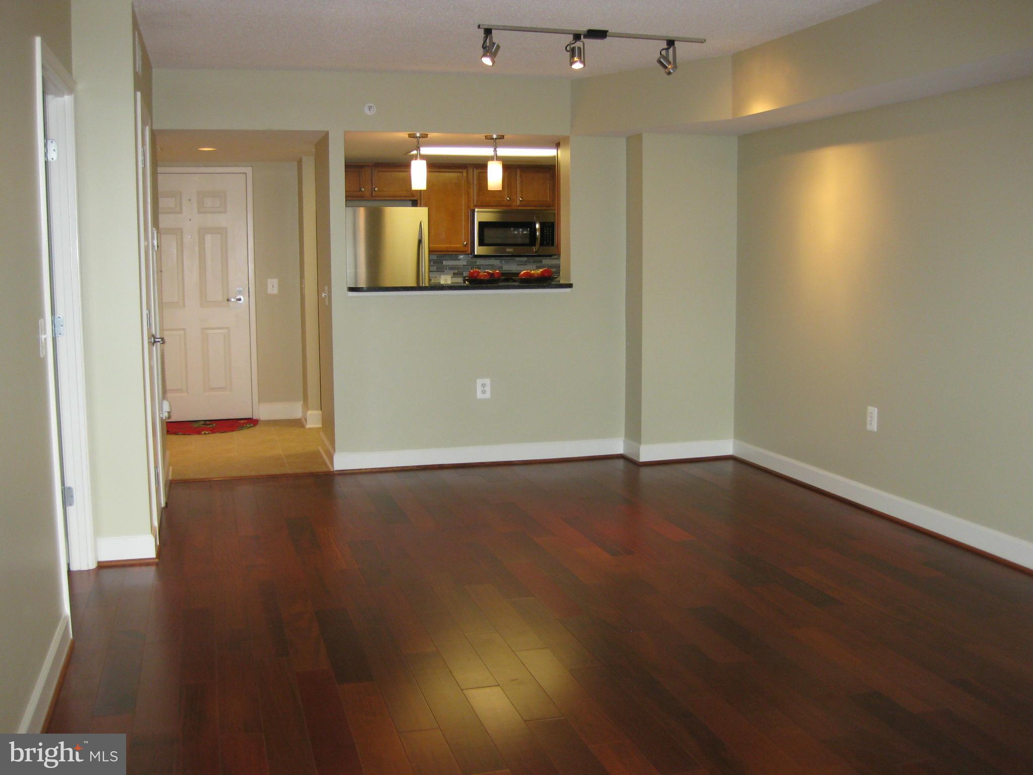 11800 Sunset Hills Road, Unit 925 Reston, VA 20190 - Photo 3 of 29 an empty room with wooden floor and windows
