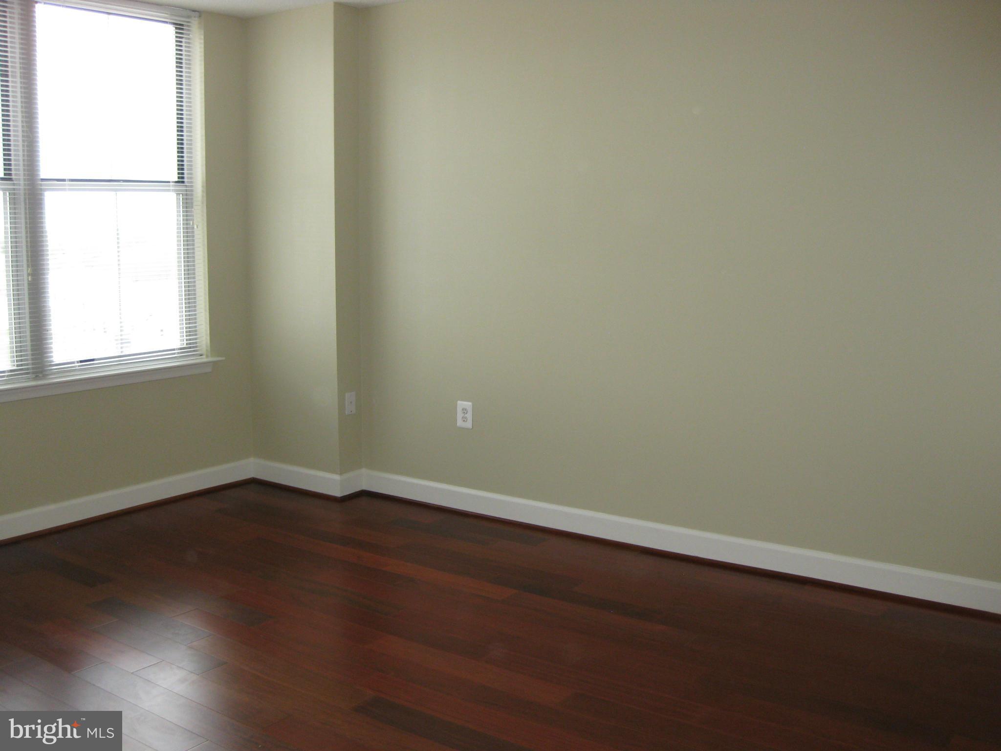 11800 Sunset Hills Road, Unit 925 Reston, VA 20190 - Photo 4 of 29 an empty room with wooden floor and windows