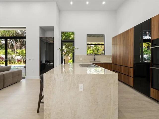 a living room with furniture a ceiling fan and a large window