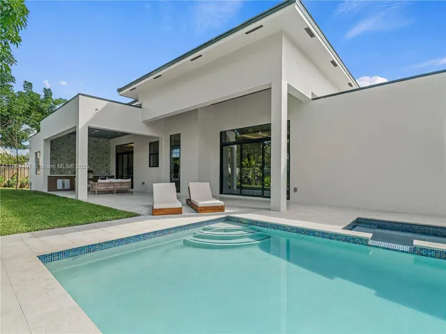 a view of a swimming pool with outdoor seating and plants