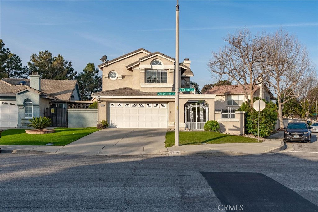 10979 Charleston Street Rancho Cucamonga, CA 91701 - Photo 1 of 1 a view of a white house next to a road and yard