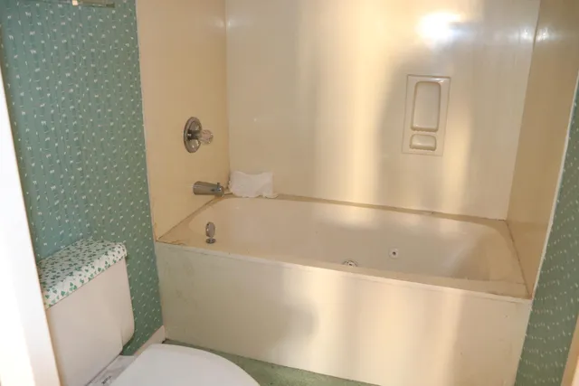 a white bath tub sitting next to a toilet