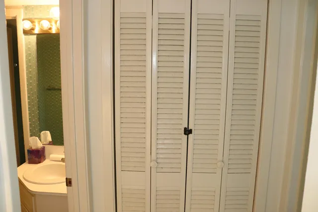 a view of a hallway with wooden floor and a dining room