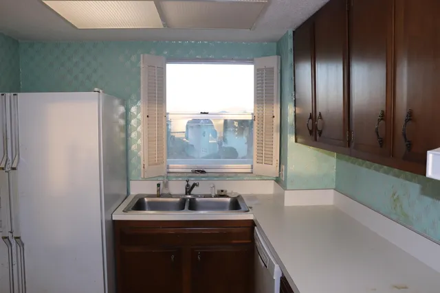 a kitchen with a sink a refrigerator and window