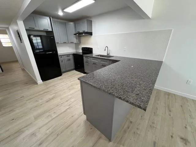 a kitchen with granite countertop a refrigerator and a sink