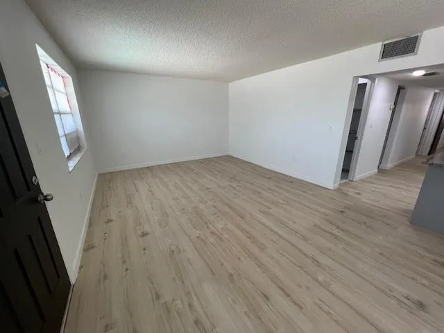 an empty room with wooden floor and staircase