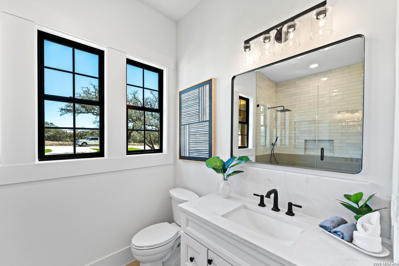 34793 High Gate Road Bulverde, TX 78163 - Photo 19 of 50 a bathroom with a sink a toilet and a large mirror