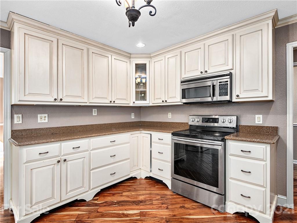 588 Lee Cudd Road Rutherfordton, NC 28139 - Photo 6 of 42 a kitchen with stainless steel appliances granite countertop a stove a sink and dishwasher with white cabinets