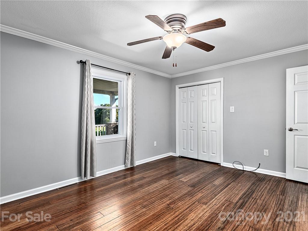 588 Lee Cudd Road Rutherfordton, NC 28139 - Photo 8 of 42 a view of an empty room with wooden floor and a ceiling fan